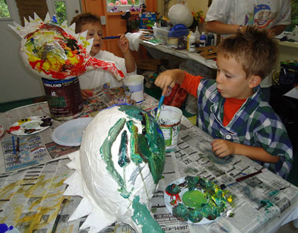 The twins applied their considerable energy and talents to painting colorful dragon piatas.